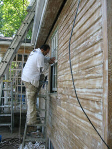 house painter working on exterior of home