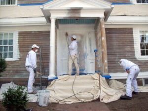 Three men applying Rhino Shield coating to front of house